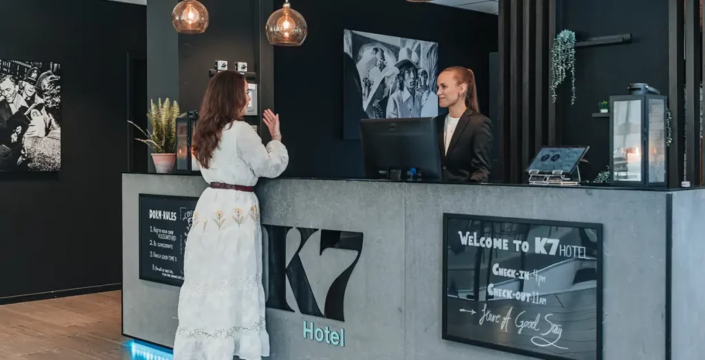 A guest talking to the receptionist at K7 Hotel Oslo
