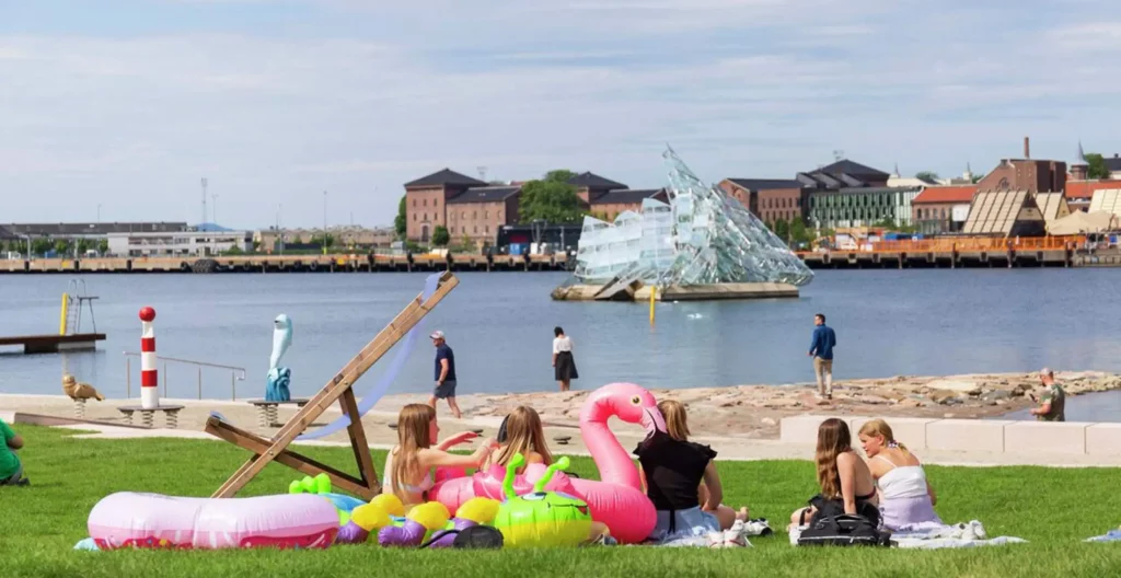 En gruppe venner sitter på stranden på Operastranda.
Foto av: Didrick Stenersen / VisitOSLO